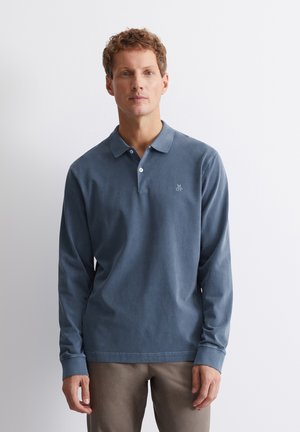 Langärmliges Polo-Shirt aus gedämpftem blauen Baumwollmaterial, mit einem button-down Kragen, dezentem Logo auf der linken Brust und gerippten Bündchen.