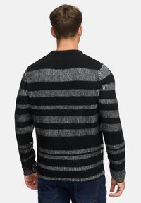 Sort og grå stribet sweater lavet af struktureret strikstof, med rund hals og lange ærmer, set fra ryggen.