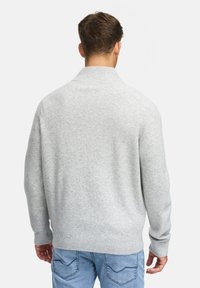 Ljusgrå tröja med ribbad krage och manschetter. Mjuk textur, avslappnad passform, baksidan visar minimal detaljer och slät finish.