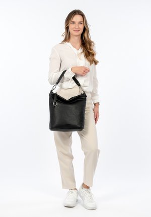 Sac à épaule en cuir noir avec une finition texturée, doté d'une fermeture zippée en haut, d'un fond arrondi et d'une sangle d'épaule réglable. Des accents ajoutent du détail.