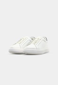 White leather sneakers with a low profile, round toe, and textured side accents. Features white laces and a lightweight rubber sole.