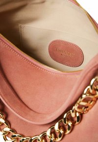 Borsa in suede rosa con tracolla in catena dorata. L'interno presenta una fodera beige e un'etichetta TWSET impresso sul lato. Chiusura con zip.