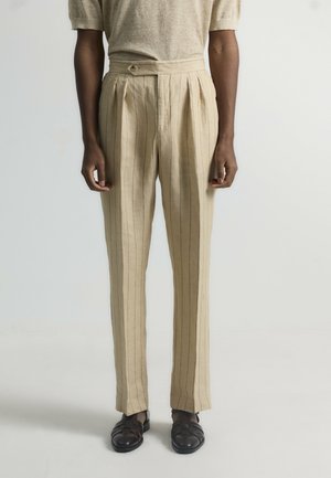 Pantalones de lino beige con rayas verticales, que presentan pliegues en la cintura y un cierre de un solo botón. Tejido texturizado y corte ajustado.