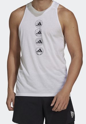 Homme portant un débardeur blanc sans manches avec quatre logos noirs Adidas en cercles au centre et un short noir avec logo Adidas sur la jambe gauche.