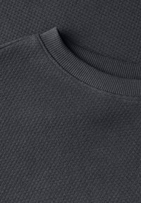Mörkgrå sweatshirt med ribbad rundhals och textilerad stoff, som visar ett diagonalt stickat mönster. Inga ytterligare detaljer förekommer.