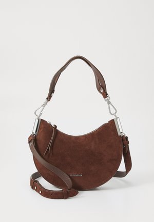 Brown suede shoulder bag with a half-moon shape, leather accents, adjustable strap, and silver hardware detail. Brand name displayed.