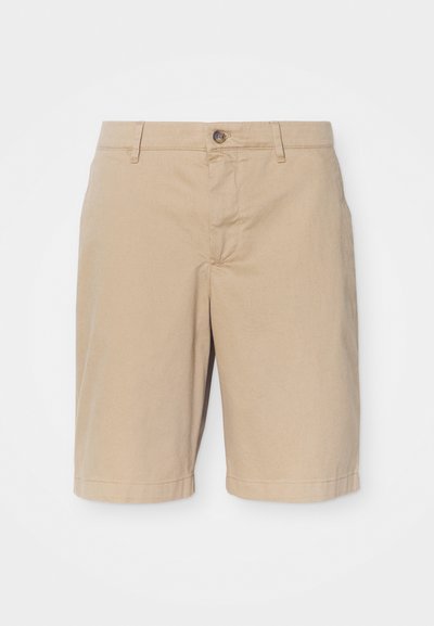 Béžové bavlněné kraťasy s hladkým povrchem, vybavené zapínáním na knoflík vpředu, poutek na opasek a rovný střih, končící těsně nad koleny.