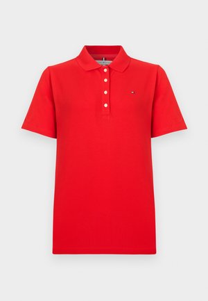 Tricou polo roșu cu mâneci scurte, prevăzut cu patru nasturi albi și un mic logo în formă de steag pe pieptul stâng.