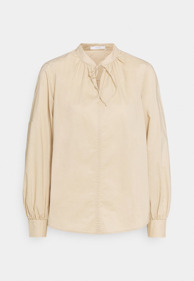 Beige långärmad blus i mjukt tyg, med rund halsringning och en knytning framtill, samt puffärmar som är gathered.