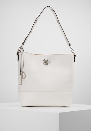 Sac seau en cuir blanc avec un fermoir tournant argenté, une bandoulière réglable et deux pampilles en cuir suspendues avec des anneaux argentés.