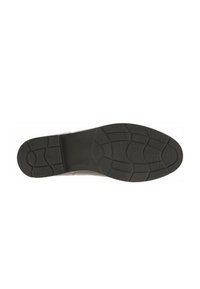 Semelle de chaussure en caoutchouc noir avec un motif texturé, présentant une adhérence à picots pour une traction et une surface centrale lisse pour le confort.