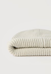 Πτυσσόμενο ανοιχτό μπεζ πλεκτό σκουφί με ραβδώσεις σε λευκό φόντο.