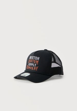 Črna mrežasta kamionska kapa z vezenim napisom "Brixton Custom Supply Company" v beli in oranžni barvi na sprednjem panelu, prikazana pod kotom, da je videti stranski mrežasti del.