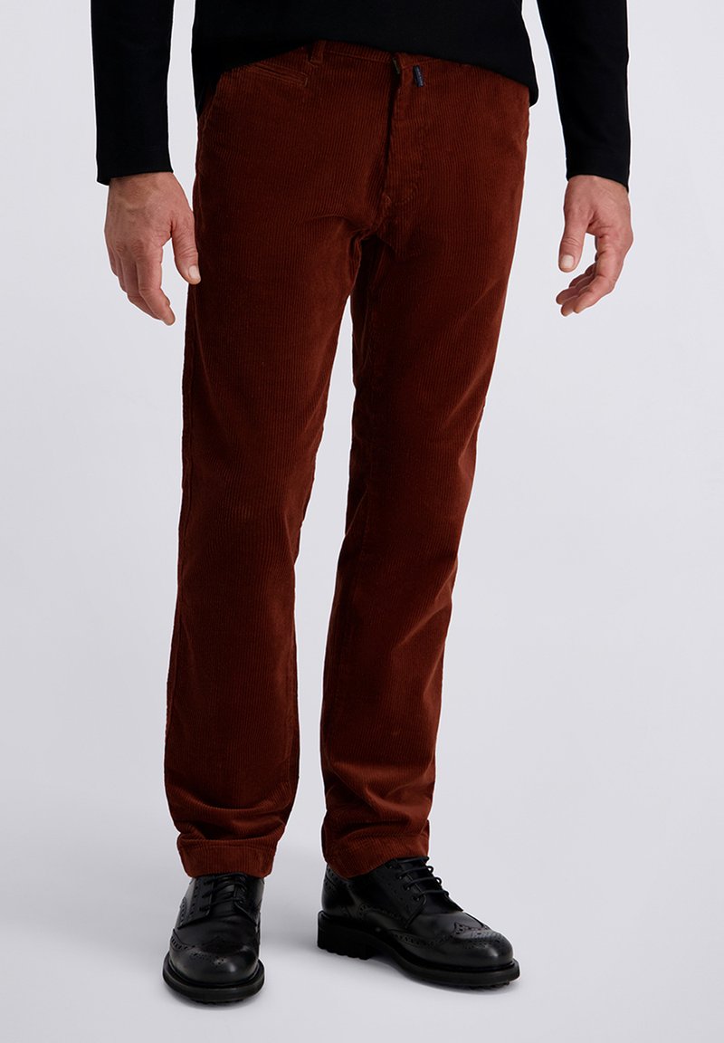 Brown corduroy trousers with a straight fit, featuring textured vertical ridges, classic pockets, and a zip fly, paired with black dress shoes.