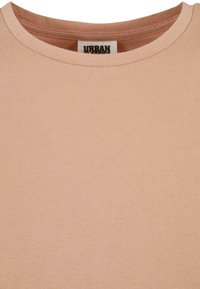 Helles rosa T-Shirt mit Rundhalsausschnitt, aus weichem Stoff gefertigt, mit glatter Textur und minimaler Nahtverarbeitung. Verfügt über ein sichtbares Markenetikett im Inneren.