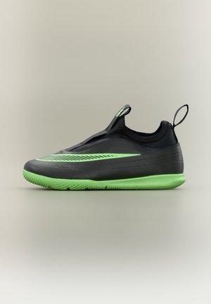 Scarpa da ginnastica nera e verde neon modello slip-on con suola verde e dettaglio swoosh verde neon sul lato, su uno sfondo chiaro semplice.