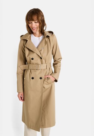 Manteau beige en trench avec un devant à double boutonnage, une taille ceinturée et des poches latérales. Doté d'une capuche et de boutons noirs. Tissu lisse et léger.
