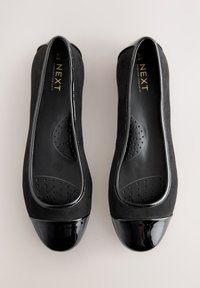 Paar schwarze Damen-Ballerinas mit glänzenden Lackkappen und gepolsterten Innensohlen, gekennzeichnet mit "NEXT Forever Comfort" Größe 40.