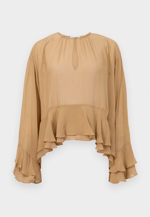 Beige long-sleeve blouse with ruffled hem and cuffs, round neckline with small front keyhole detail, loose and flowy fabric.