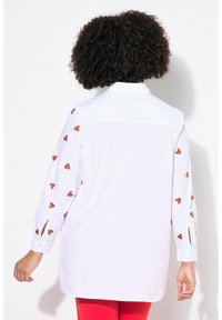 Camicia bianca con bottoni, caratterizzata da ricami a forma di cuore rossi sulle maniche, maniche lunghe con fessure ai polsini e design a taglio dritto.