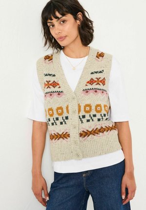 Strickweste in Cremefarbe mit bunten floralen und geometrischen Mustern, Knopfverschluss und lockerer Passform über einem weißen Hemd.