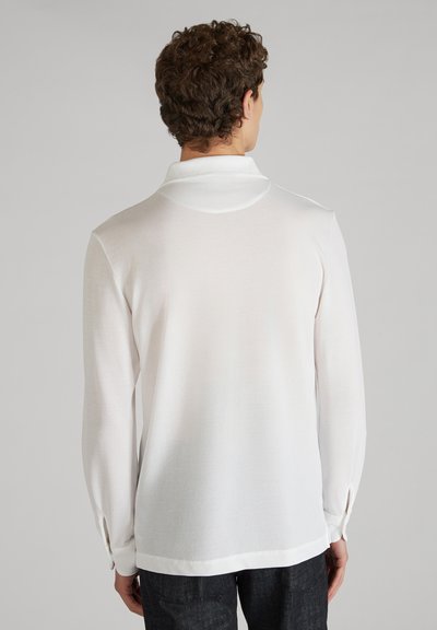 Witte langarmshirt met een relaxed fit, met een kraag, knoopmanchetten en een zachte textuur. Achteraan benadrukt het het minimalistische ontwerp.