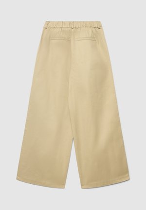 Pantaloni beige a gamba larga con vita elasticizzata, due tasche posteriori e una texture liscia, caratterizzati da un design minimalista e senza elementi visibili.