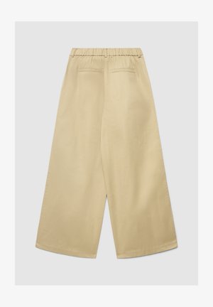 Pantaloni beige a gamba larga con vita elasticizzata, due tasche posteriori e una texture liscia, caratterizzati da un design minimalista e senza elementi visibili.
