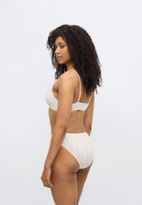 Σετ με σουτιέν από μπεζ δαντέλα και ψηλόμεσο σλιπ, με ριμπ υφή και περίτεχνα σχέδια. Ρυθμιζόμενοι ιμάντες στο σουτιέν για προσαρμοσμένη εφαρμογή.