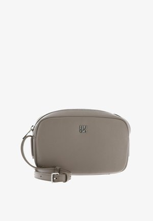 Sac bandoulière en cuir texturé gris avec fermeture éclair, bandoulière réglable et logo "HUGO" embossé sur le devant. Forme rectangulaire compacte.