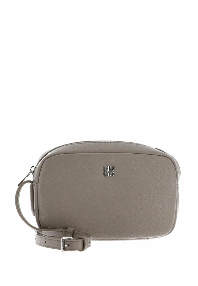 Sac bandoulière en cuir texturé gris avec fermeture éclair, bandoulière réglable et logo "HUGO" embossé sur le devant. Forme rectangulaire compacte.