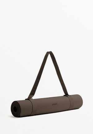 Bruine yogamat opgerold en vastgemaakt met een bijpassende band. Heeft een gestructureerd oppervlak en subtiele branding. Glad cilindervormig ontwerp.