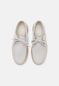 Scarpe in pelle grigio chiaro con una texture liscia, design lace-up e suola in gomma con un motivo rigato per una migliore aderenza. Branding sottile sulla soletta.