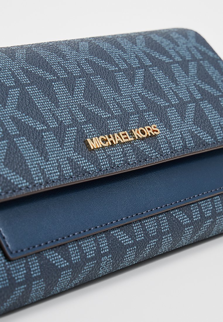 Portafoglio blu navy con tessuto testurizzato caratterizzato da un motivo a logo, hardware dorato "MICHAEL KORS" e un accentuazione in pelle blu liscia.