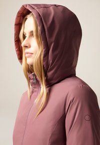 Eng anliegende, mit Reißverschluss versehene Jacke in Mauvefarbe, mit gefütterter Kapuze, glatter Textur und Logoakzent auf dem Ärmel.