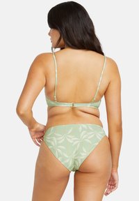 Zeleni bikini set s uzorkom lišća, podesivim trakama i kopčanjem. Tkanina ima glatku, sjajnu teksturu.