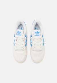 Vita sneakers med tre blå ränder, rund tå, texturerad läder, perforerat ovandel och framträdande logotyp på tungan.