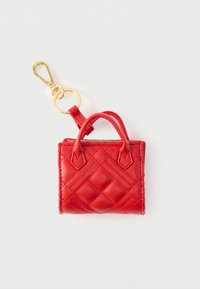 Κόκκινο μίνι μπρελόκ τσάντας κατασκευασμένο από καπιτονέ υλικό, με χρυσά μεταλλικά στοιχεία, δύο μικρές λαβές και κλιπ στερέωσης.