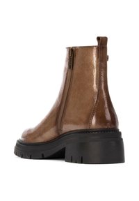 Botas de tobillo de charol marrón con cremallera lateral, suela de goma negra gruesa, superficie texturizada y diseño de punta redonda.