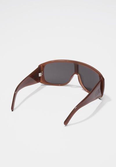 Rjave plastične sončne očala s temnimi lečami, pravokotne oblike in širokimi ročaji. Ročaji vsebujejo subtilno blagovno znamko in gladko, sijočo površino.