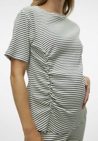 Ribadeemaline rasedusshirt valge ja tumesinise triibuga, külgmiste rütmidega ja lühikeste varrukatega. Pehme ribaline tekstuur tagab mugavuse ja sobivuse.