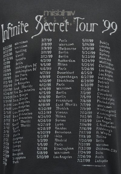 Ημερομηνίες και πόλεις περιοδείας για την Infinite Secret Tour 1998-1999, αναγραφόμενες με λευκό κείμενο σε μαύρο φόντο σε στυλ χειρόγραφης σχεδίασης.