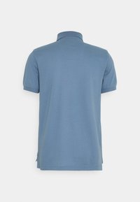 Manskjorta med kort ärm i ljusblått med ett enfärgat mönster, med en ribbad krage och sidofickor f ör ökad rörlighet.