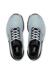 Light gray athletic shoes with mesh upper, green accents, and white laces. Features black inner lining and logo on the tongue.