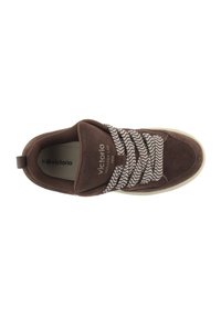 Sneaker marrone con tomaia in suede, caratterizzata da un lacciato bianco e marrone con motivo e suola in gomma beige. Logo visibile di lato.