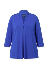 Camicia tunica a V in blu reale, realizzata in tessuto morbido. Presenta maniche a tre quarti e dettagli con piega frontale.