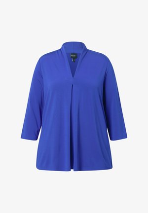 V-Ausschnitt Tunika-Shirt in einfarbigem Königsblau, aus weichem Stoff. Mit drei Viertel-Ärmeln und einer Vorderfalten-Details.