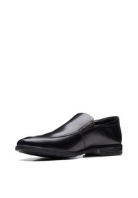 Schwarzer Slipper aus glänzendem Leder. Mit abgerundetem Zehenbereich, dezenten Nähten und einer strukturierten Gummisohle. Minimalistisches Design.