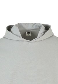 Lys grå hættetrøje med en glat tekstur, der har et enkelt design og et mærkelabel synligt inden i kraveområdet.