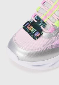 Light-up athletic shoe with a metallic silver and pink upper, textured design, reflective accents, and neon green laces. "I LIGHT UP" tag.